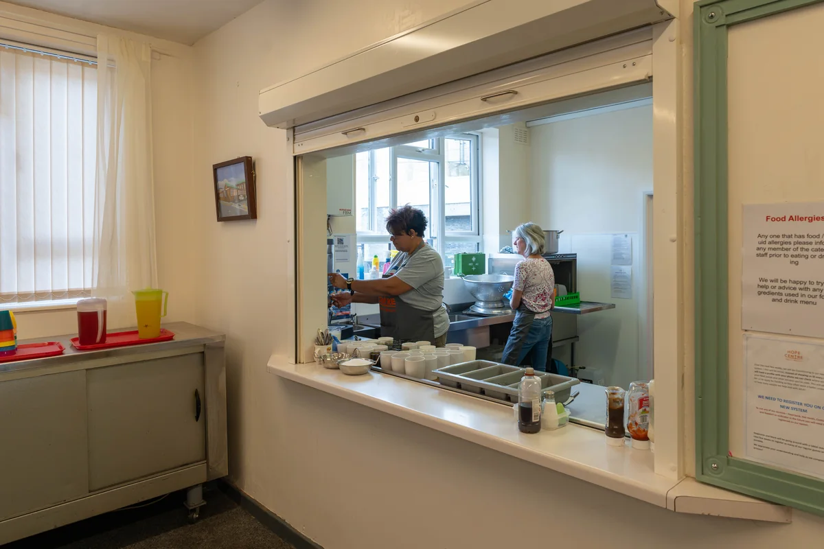 Kitchen serving hatch with volunteers preparing meals at Trinity Mission Hope Centre