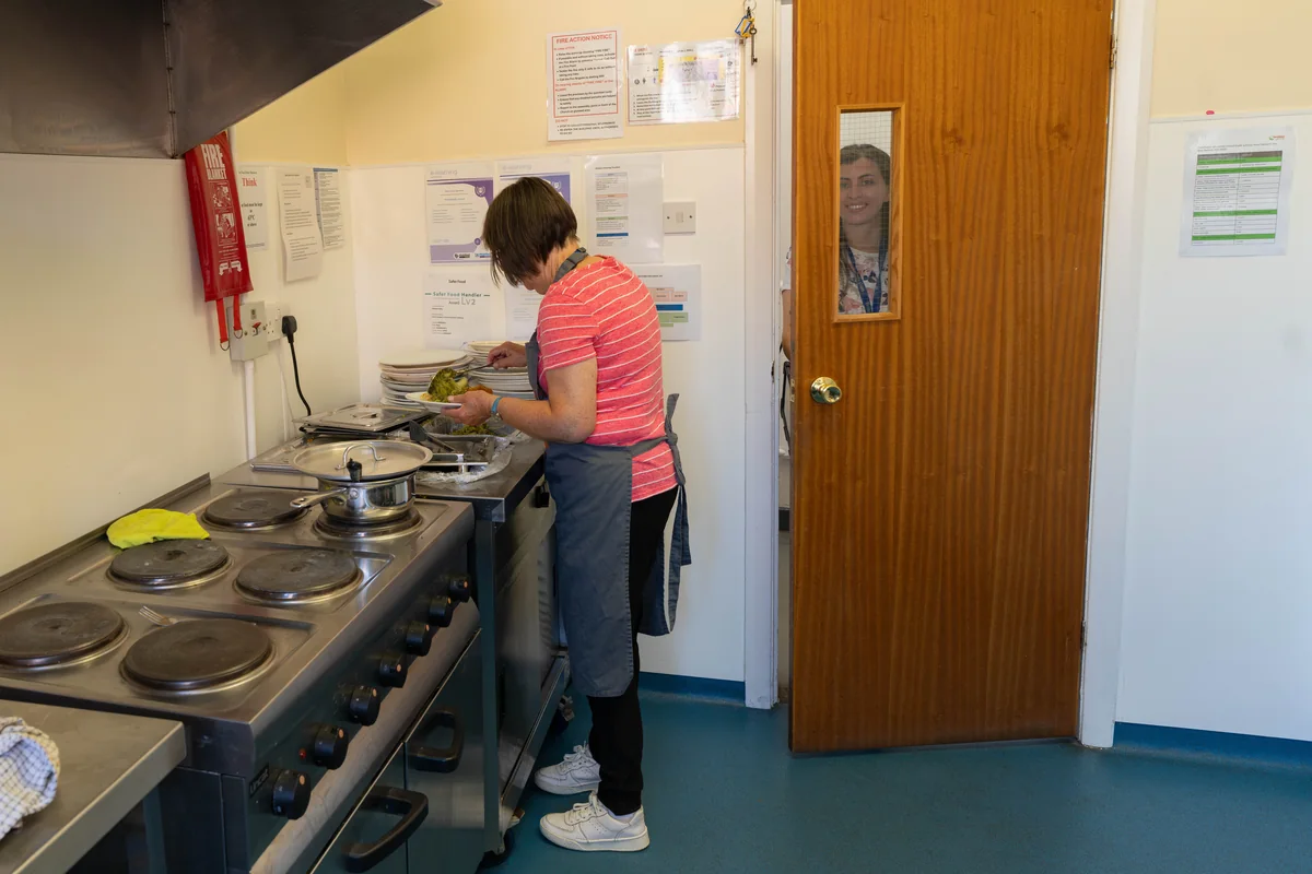 Volunteer preparing and plating nutritious lunches in the Trinity Mission kitchen