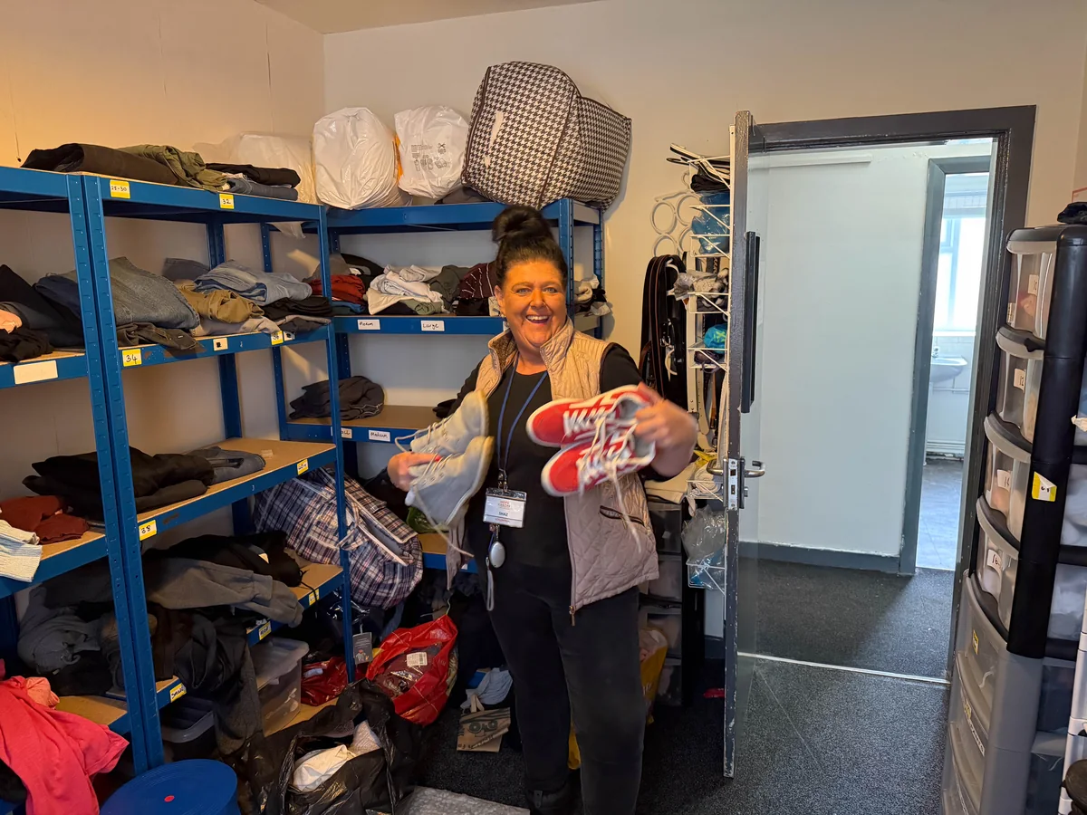 Trinity Mission volunteer sorting donated footwear and winter clothing in the clothing bank